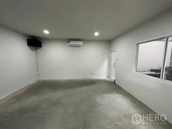 Warehouse for rent in Bang Bua Thong, Nonthaburi - Clean office room inside the warehouse with white walls, a window, air conditioning, and a concrete floor.