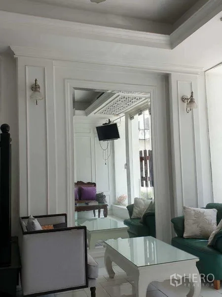 零售空间 出租在Huai Khwang, Bangkok - 雅致休息区，沙发、玻璃茶几与装饰墙线条。