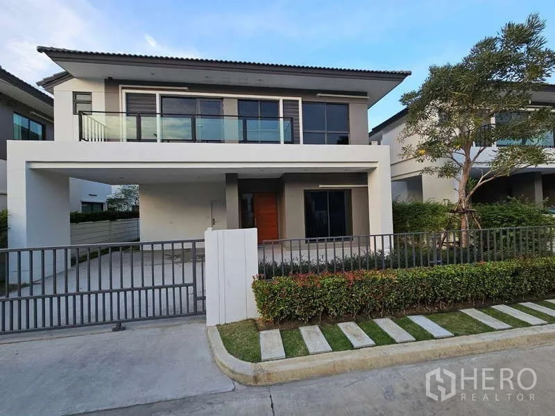 Detached House for rent in Bang Phli, Samut Prakan - Modern two-storey detached house at Nirati Bangna with balcony, sliding gate and 2-car carport.