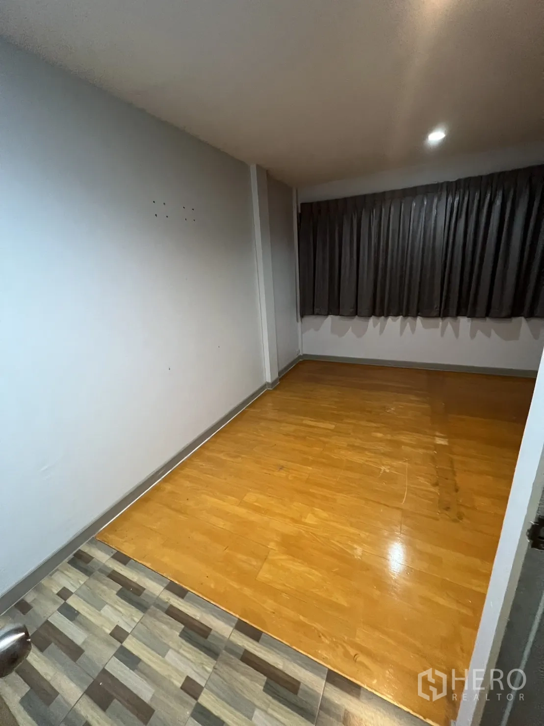 联排别墅 出租在Watthana, Bangkok - 小巧房间，木质复合地板与深色窗帘。