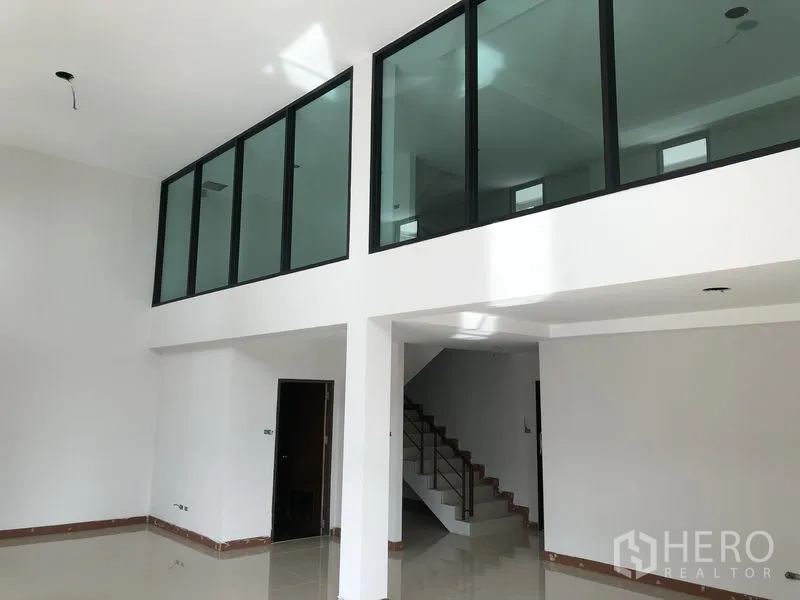 Factory for rent or sale in Bang Bua Thong, Nonthaburi - Office lobby with double-height ceiling, glass-walled mezzanine and staircase.