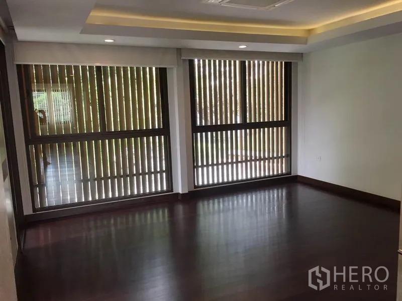 Detached House for rent in Sathon, Bangkok - Bedroom with dark wood flooring and wide windows fitted with vertical slat blinds