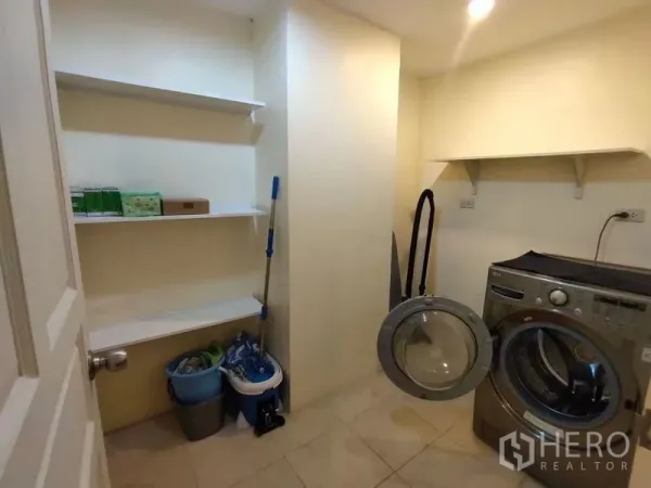 Condominium for rent or sale in Bang Rak, Bangkok - Utility room with wall shelves and a front‑load washing machine.