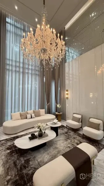Detached House for sale in Saphan Sung, Bangkok - Double-volume living room with 7-metre ceiling, crystal chandelier, floor-to-ceiling drapes and designer seating.