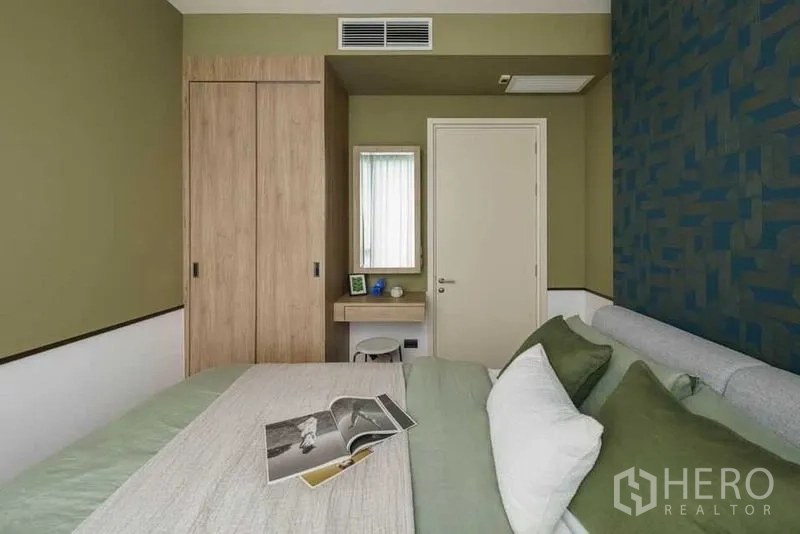 公寓 出租在Watthana, Bangkok - 次卧以绿色为主调，内置衣柜与小型书桌。