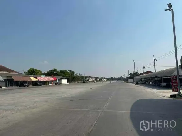 พื้นที่ขายปลีก ให้เช่าในPathum Thani - ถนนภายในโครงการยาว มีเสาไฟและร้านค้าทางด้านซ้าย