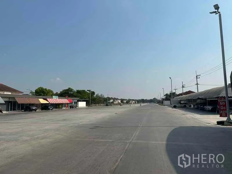 พื้นที่ขายปลีก ให้เช่าในPathum Thani - ถนนภายในโครงการยาว มีเสาไฟและร้านค้าทางด้านซ้าย