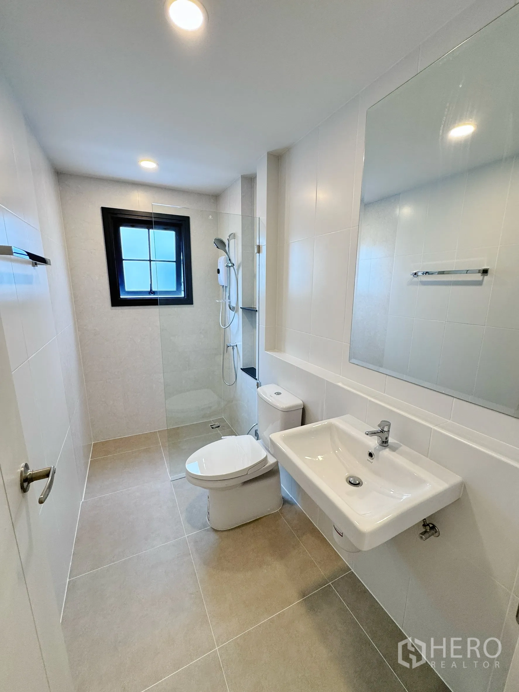 Detached House for rent in Bang Phli, Samut Prakan - Bright bathroom with glass shower, window, and white sanitary ware.
