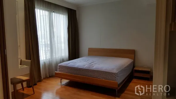 คอนโด ให้เช่าในKhlong Toei, Bangkok - ห้องนอนสว่าง เตียงใหญ่ พื้นไม้ มุมโต๊ะทำงาน และหน้าต่างบานใหญ่พร้อมผ้าม่าน