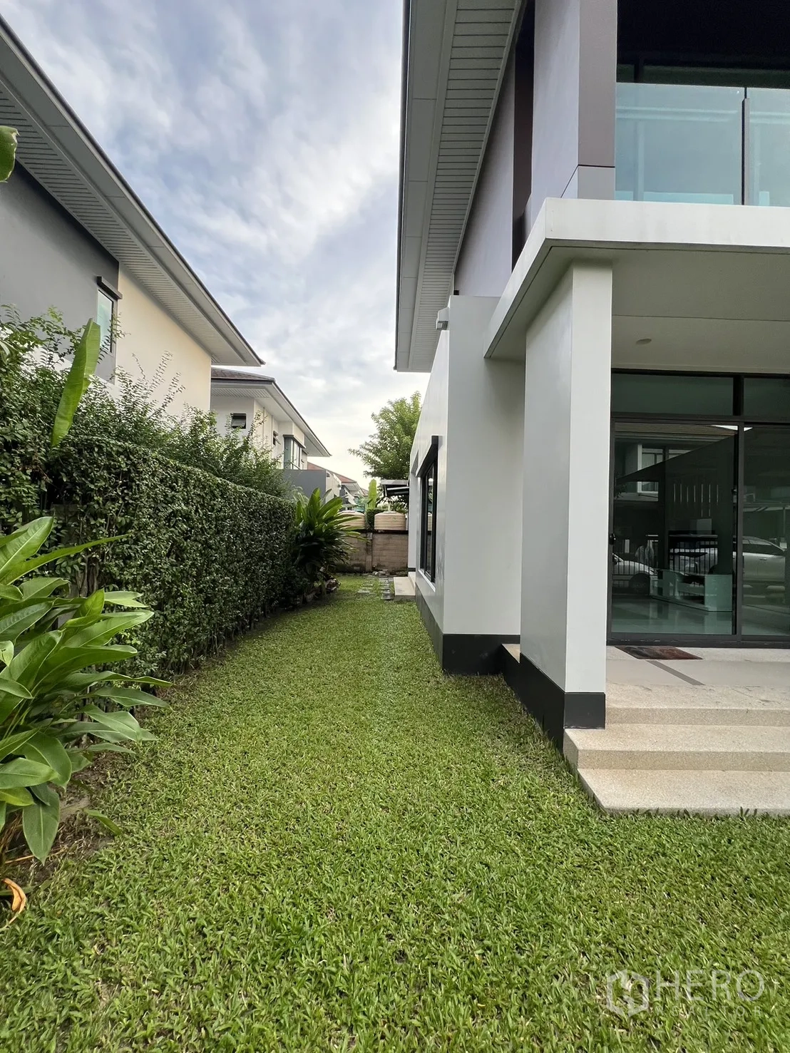 บ้าน ให้เช่าในBang Kapi, Bangkok - สนามหญ้าด้านข้างยาวติดแนวพุ่มไม้ข้างตัวบ้าน