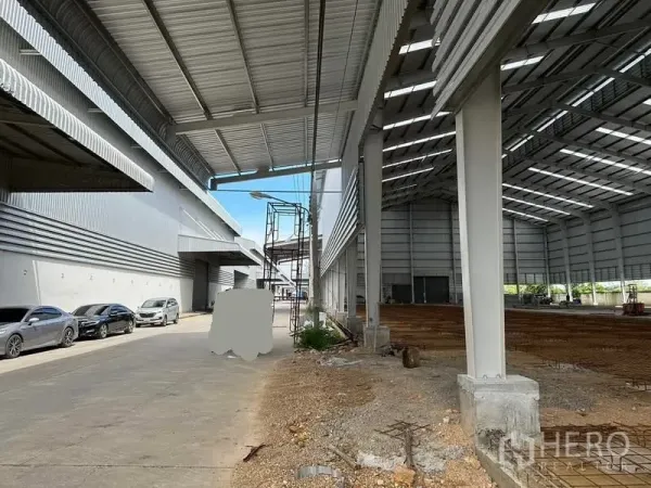 คลังสินค้า ให้เช่าในWang Noi, Phra Nakhon Si Ayutthaya - ชายคาโหลดสินค้ามีหลังคา ข้างอาคารโกดังที่กำลังก่อสร้าง มีรถจอดริมทาง