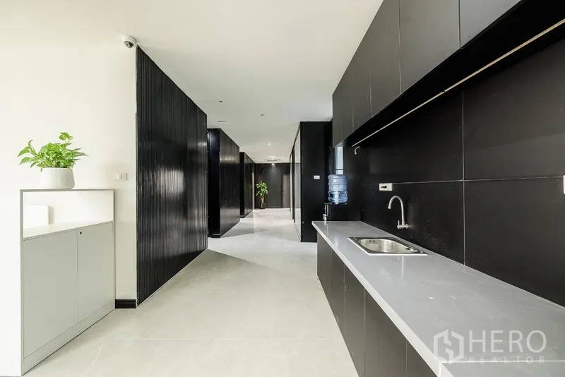 办公空间 出租或出售在Huai Khwang, Bangkok - 走廊一侧的茶水区，长台面、水槽与饮水机。