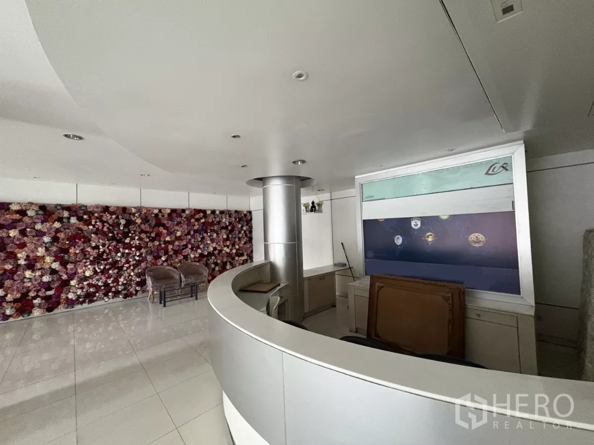 办公空间 出租在Watthana, Bangkok - 弧形前台与花艺装饰墙。