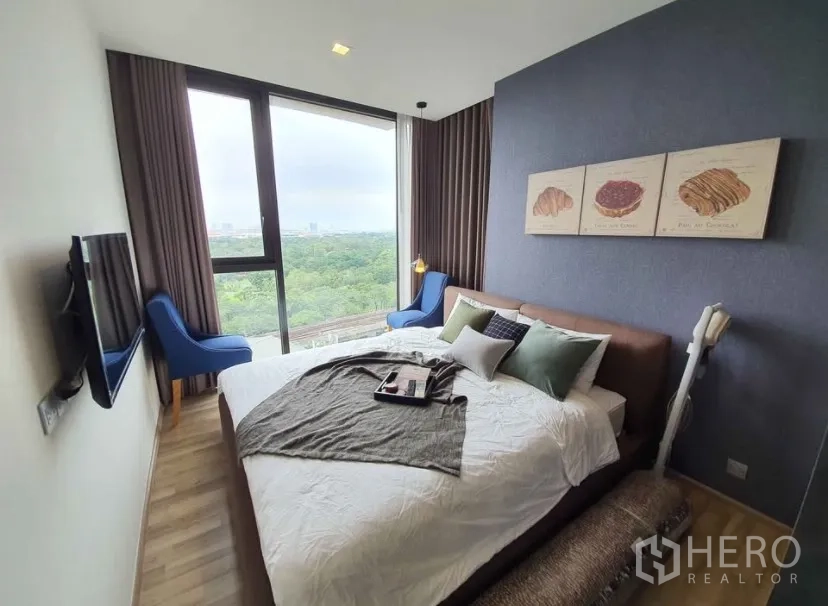 Condominium for rent in Chatuchak, Bangkok - Bright bedroom with floor-to-ceiling windows and expansive green views.