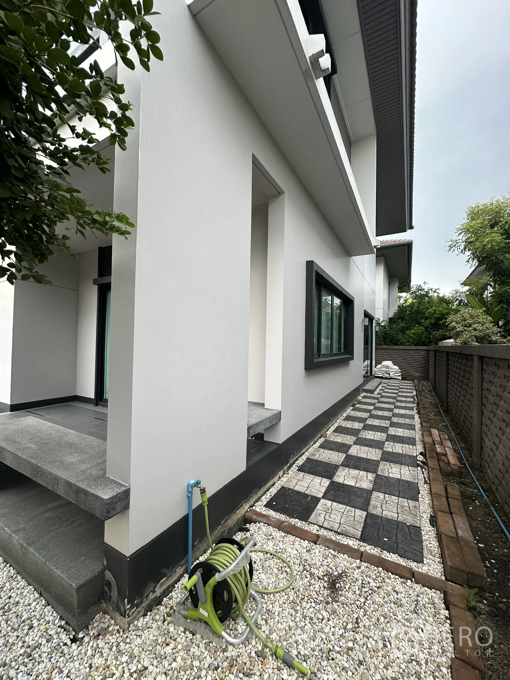 บ้าน ให้เช่าในLam Luk Ka, Pathum Thani - ด้านข้างบ้านปูบล็อกตาราง กรวด และสายยางรดน้ำ