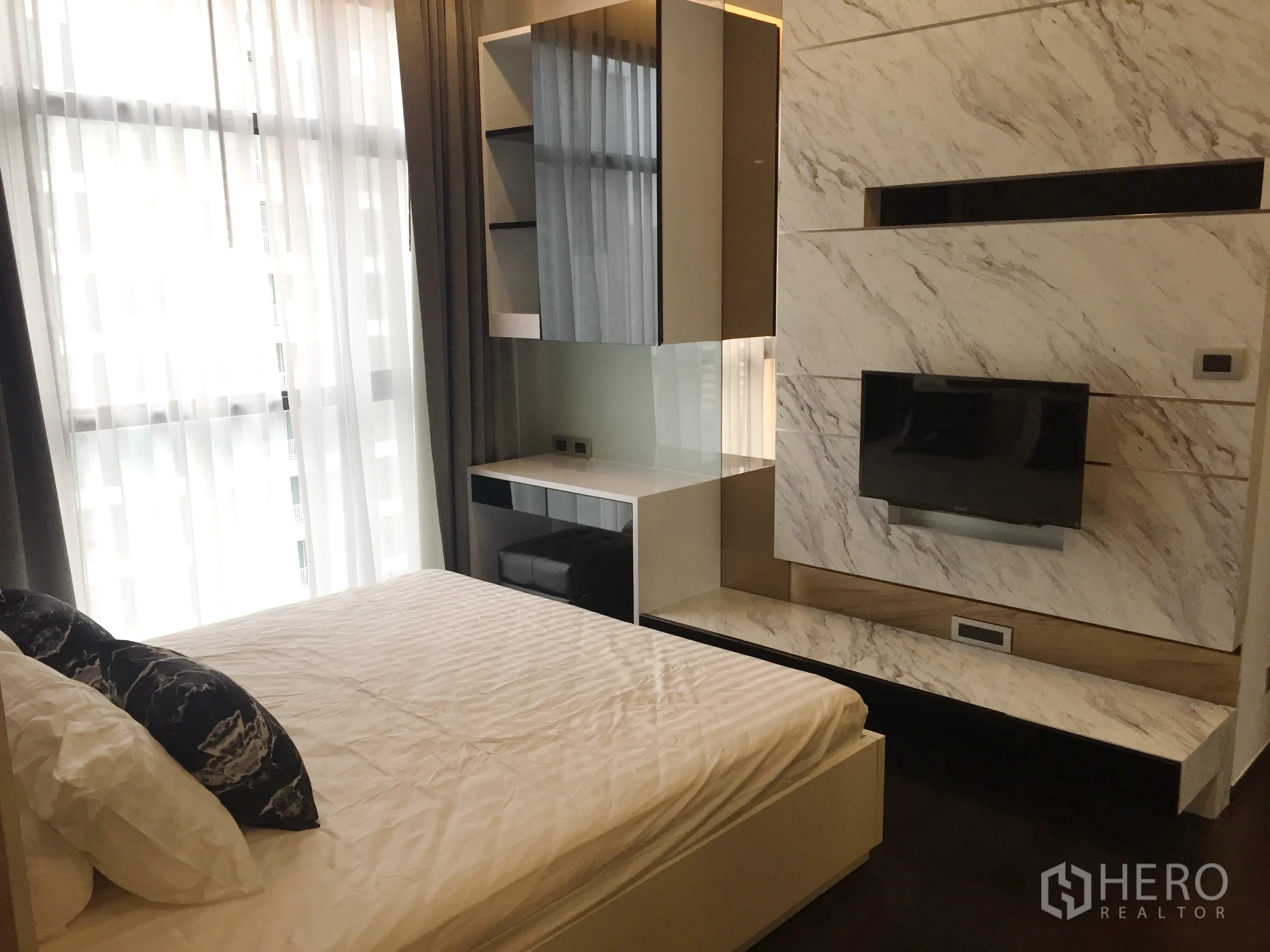 คอนโด ให้เช่าในWatthana, Bangkok - ห้องนอนสว่างด้วยหน้าต่างเต็มผนัง ผ้าม่านโปร่ง เตียง และผนังทีวีหินอ่อน