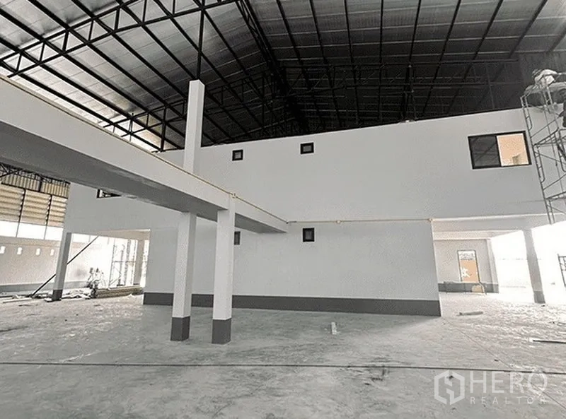 Warehouse for rent in Bang Pakong, Chachoengsao - Open-plan storage hall with mezzanine structure, white columns and metal roof.