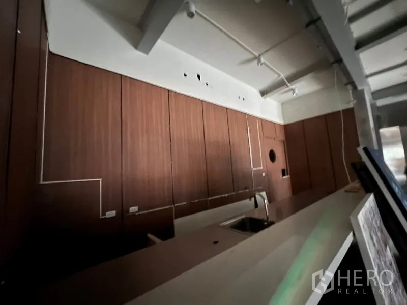 零售空间 出租在Watthana, Bangkok - 吧台近景，带水槽与木质柜体的商业毛坯空间。