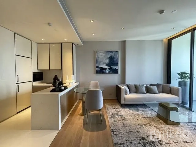Condominium for rent or sale in Khlong Toei, Bangkok - Open-plan kitchen with sleek island, dining set for two, and living area leading to the balcony.