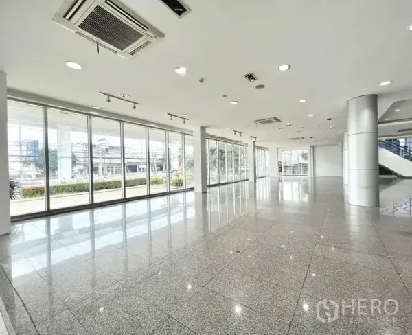 Retail Space for rent in Prawet, Bangkok - Spacious corner retail space with track lighting, columns, and panoramic glazed walls.