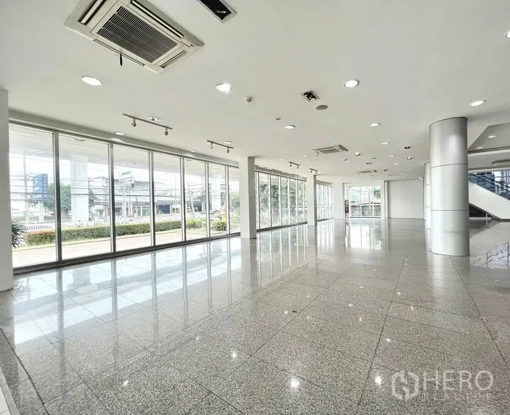 Retail Space for rent in Prawet, Bangkok - Spacious corner retail space with track lighting, columns, and panoramic glazed walls.