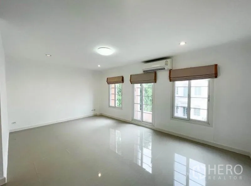 Townhouse for rent in Phasi Charoen, Bangkok - Large air-conditioned bedroom with multiple windows and balcony access.