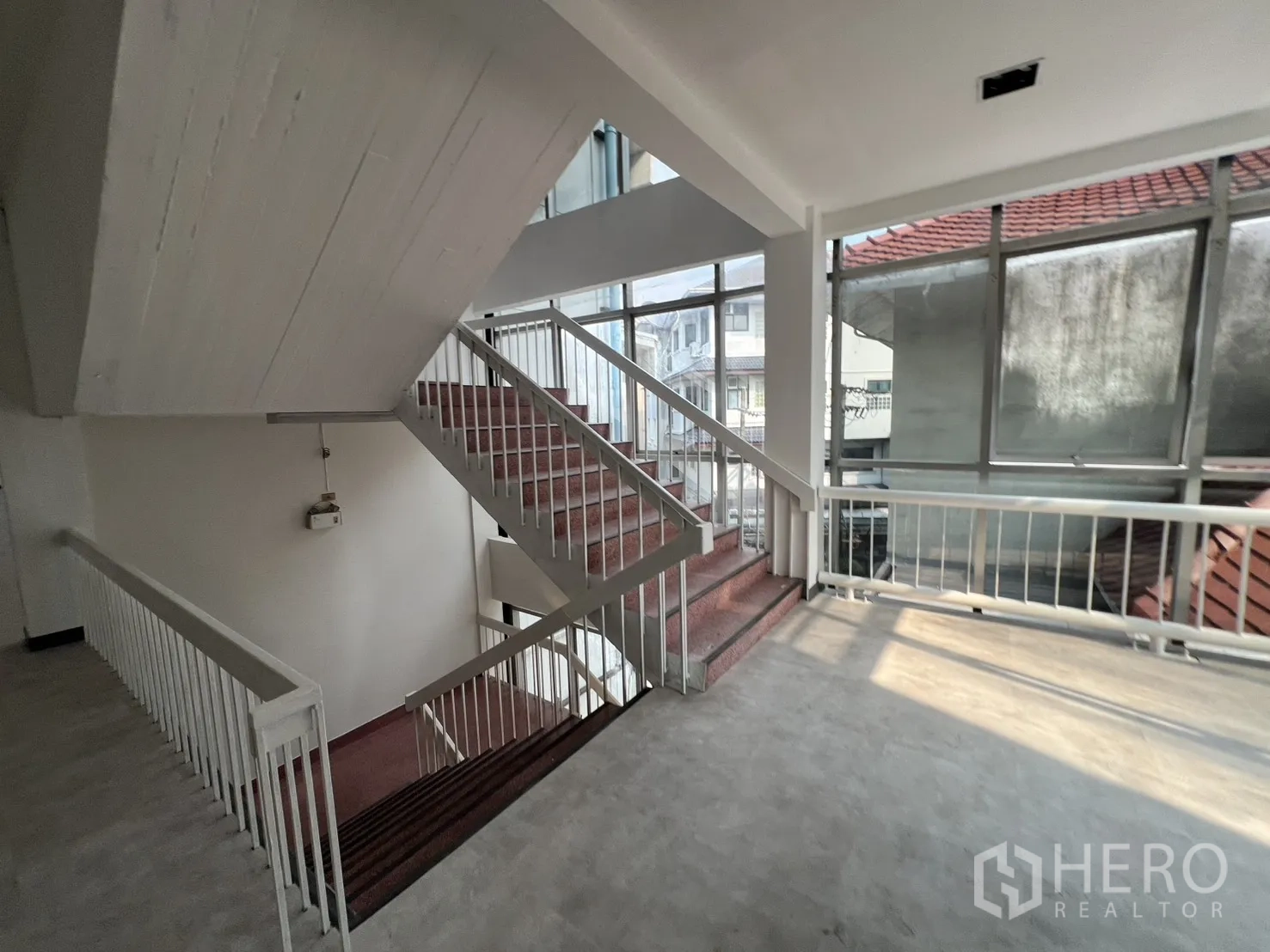 办公空间 出租在Watthana, Bangkok - 楼梯平台配大面积玻璃与白色栏杆，光线充沛。