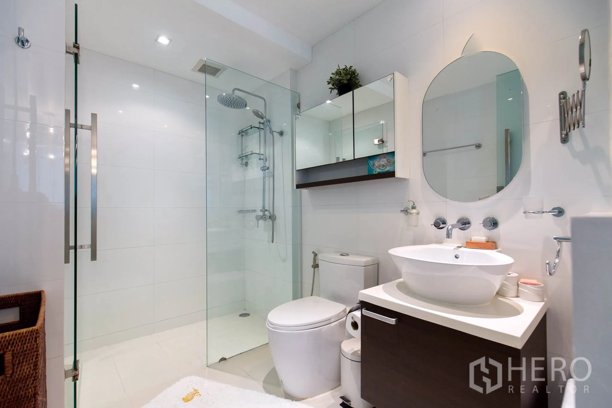 公寓 出租在Pathum Wan, Bangkok - 现代白色卫浴，玻璃淋浴间配雨淋花洒，台上盆与镜柜。