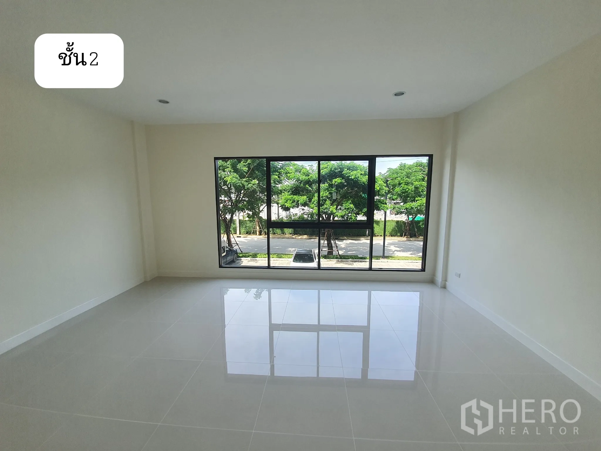 Home Office for rent or sale in Prawet, Bangkok - Second-floor workspace with large picture window overlooking trees and glossy white tile floor.