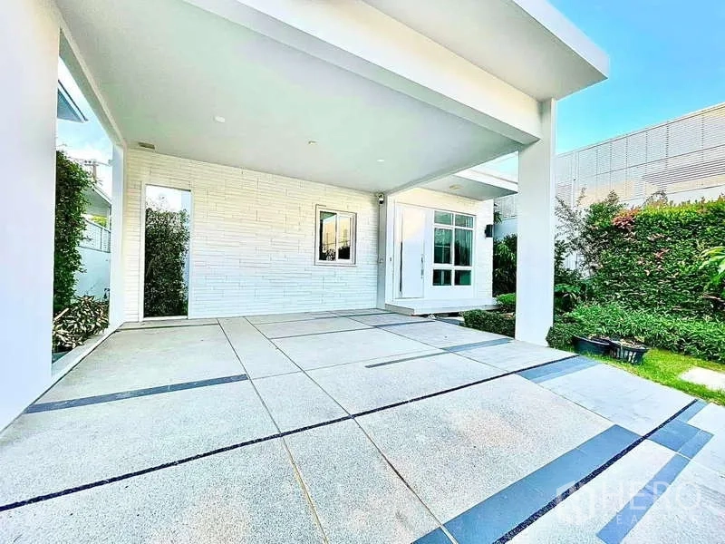 บ้าน ให้เช่าในPrawet, Bangkok - ที่จอดรถในร่มและชานหน้าบ้านปูพื้นกระเบื้อง ข้างสวนหย่อมเล็ก ๆ.