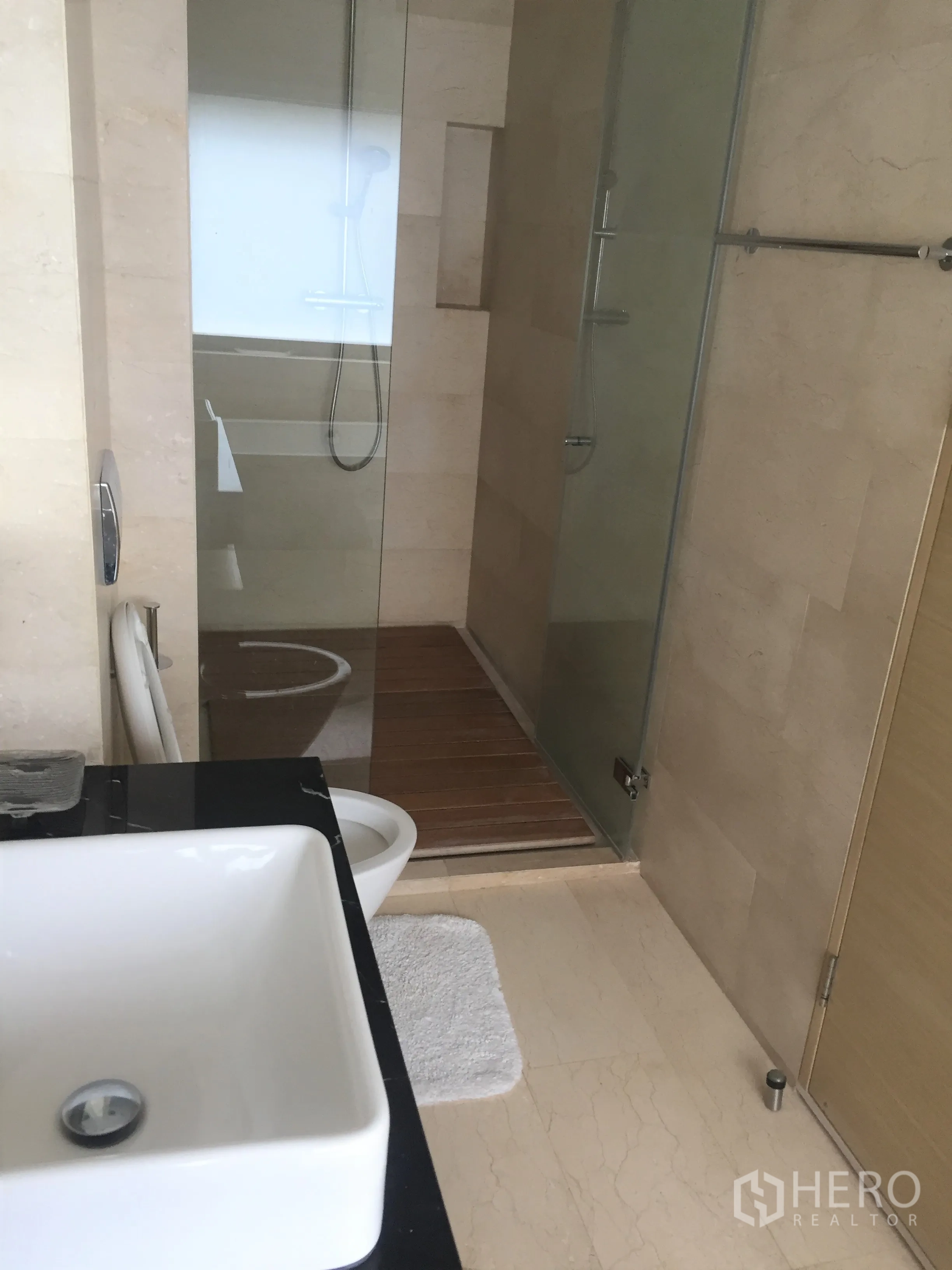 公寓 出租在Bang Rak, Bangkok - 第二浴室带玻璃淋浴间、方形台盆与浅色大理石地面。