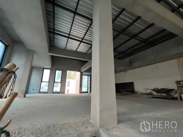 Home Office for rent in Watthana, Bangkok - Spacious shell-and-core home office floor with high ceilings, concrete columns and tall windows.