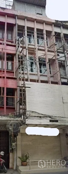 อาคารพาณิชย์ ให้เช่าในKhlong Toei, Bangkok - ด้านหน้าตึกแถว 4 ชั้นบนสุขุมวิท มีนั่งร้านและประตูม้วนปิด