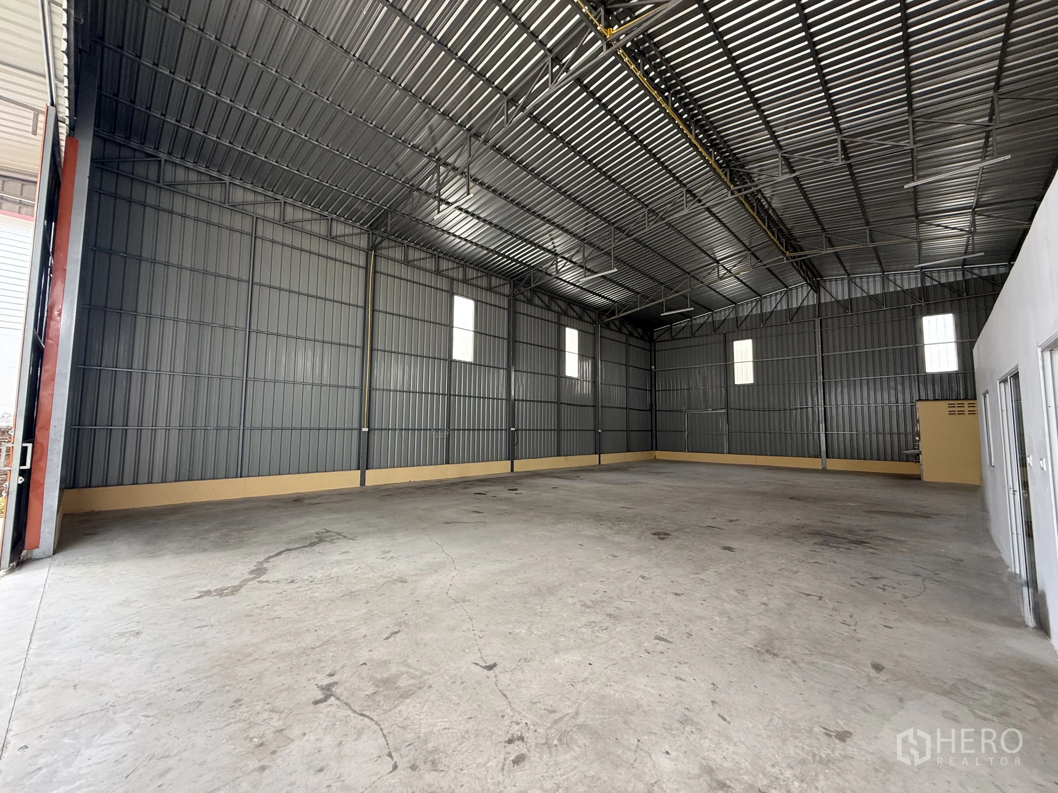 Warehouse for rent in Wang Thonglang, Bangkok - Open warehouse interior with high steel roof and smooth concrete floor.