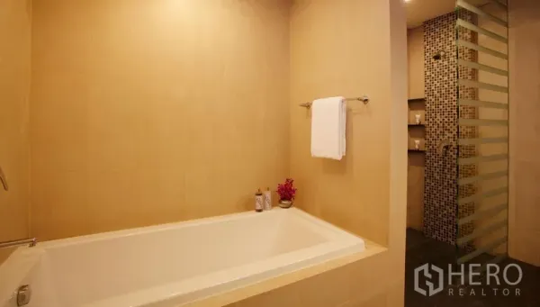 Condominium for rent in Watthana, Bangkok - Light bathroom with a full-size soaking tub and a separate glass mosaic shower.