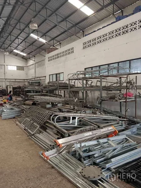 Warehouse for rent or sale in Nong Suea, Pathum Thani - Driveway leading to multiple gable-roof warehouse buildings.