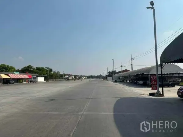 พื้นที่ขายปลีก ให้เช่าในPathum Thani - พื้นที่คอนกรีตกว้าง มีเต็นท์ขายสินค้าด้านขวาและหน้าร้านด้านซ้าย เหมาะสำหรับจอดรถ