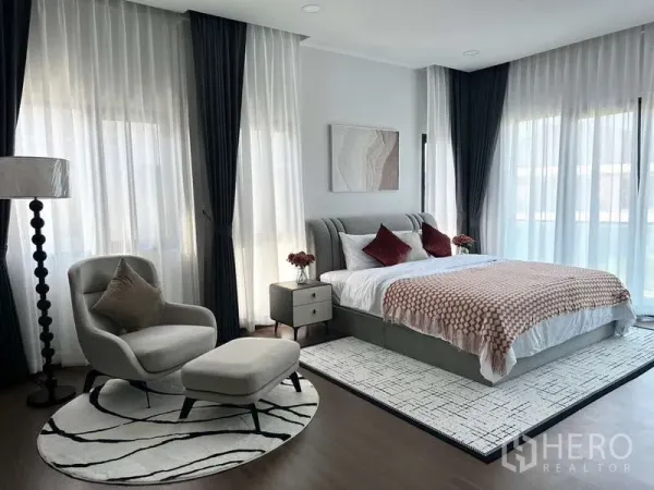 บ้าน ให้เช่าในBang Phli, Samut Prakan - ห้องนอนใหญ่สว่างไสว ม่านโปร่ง เก้าอี้พักผ่อน และพรมลายสวย