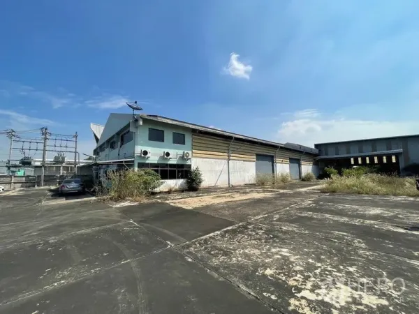 คลังสินค้า ให้เช่าหรือขายในBang Bon, Bangkok - ด้านข้างอาคารพร้อมประตูม้วนขนถ่ายสินค้าและลานคอนกรีตกว้าง