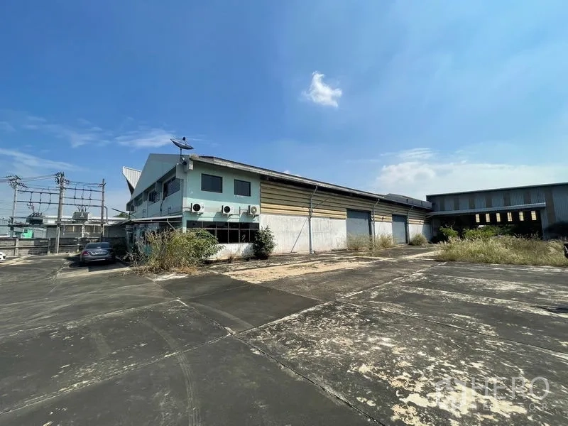 คลังสินค้า ให้เช่าหรือขายในBang Bon, Bangkok - ด้านข้างอาคารพร้อมประตูม้วนขนถ่ายสินค้าและลานคอนกรีตกว้าง