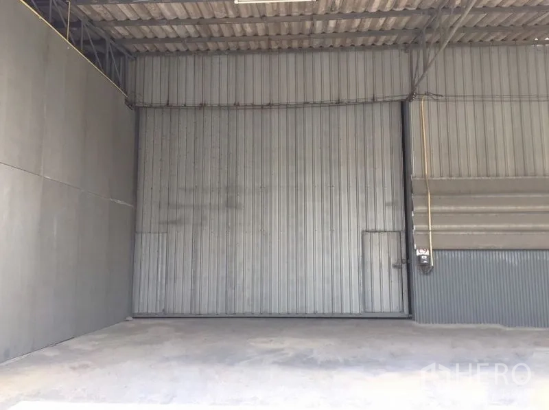 货栈 出租在Prawet, Bangkok - 仓库内部，设有大型波纹金属推拉门与平整混凝土地面。