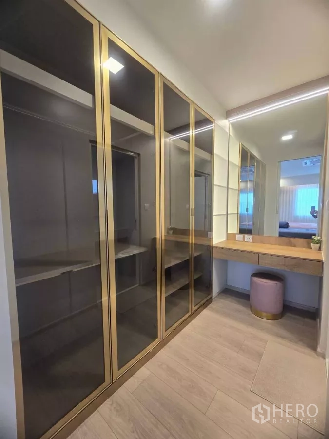 Detached House for rent in Bang Phli, Samut Prakan - Walk-in closet with glass-front wardrobes, vanity table, mirror and stool.