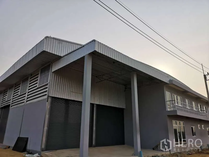 货栈 出租在Khlong Luang, Pathum Thani - 仓库外观，带雨棚装卸区、卷闸门与一体式办公楼，位于空銮县。