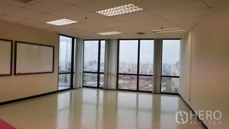 办公空间 出租在Din Daeng, Bangkok - 转角办公室，落地窗配白板，俯瞰曼谷天际线。