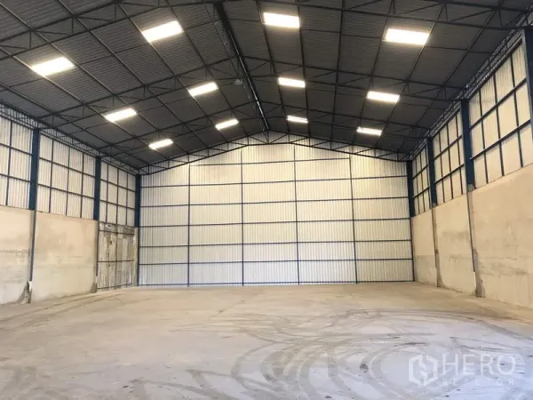 货栈 出租在Pathum Thani - 高挑钢结构仓库内部，LED照明明亮，混凝土地坪平整宽阔。