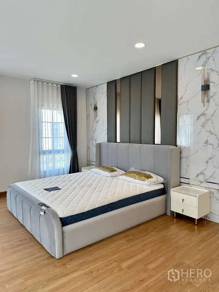 บ้าน ให้เช่าในBang Phli, Samut Prakan - ห้องนอนหรู ผนังตกแต่งลายหินอ่อน หัวเตียงบุนวม และโคมไฟข้างเตียง