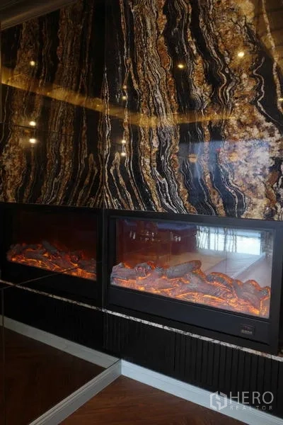 คอนโด ขาย - ผนังหินอ่อนพร้อมเตาผิงไฟฟ้าคู่ ในพื้นที่นั่งเล่นคอนโดระดับพรีเมียม