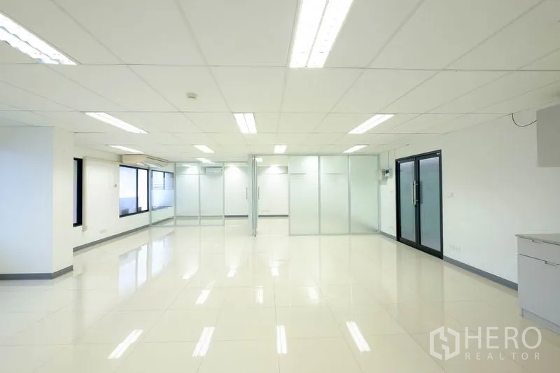 办公空间 出租在Chatuchak, Bangkok - 采光充足的办公室，亮面地砖、吊顶日光灯和磨砂玻璃墙。