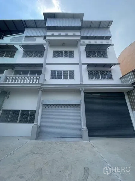Warehouse for rent in Mueang Samut Sakhon, Samut Sakhon - Front elevation of the warehouse building with metal awnings and roller shutters.