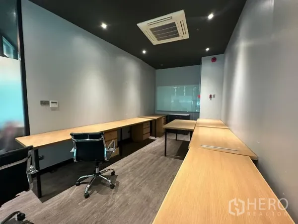 Office Space for rent - Private 17 sqm office with long built-in desks, task chairs, carpet flooring, ceiling cassette AC and glass partition.
